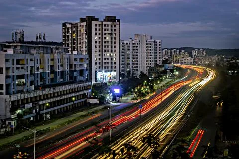 Low shutter speed image of beautiful sky , buildings and flowing traffic on m Stock Photos