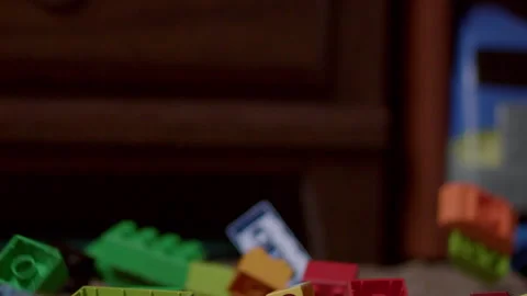 Low side view of legos breaking apart on a carpet Video stock 245402497