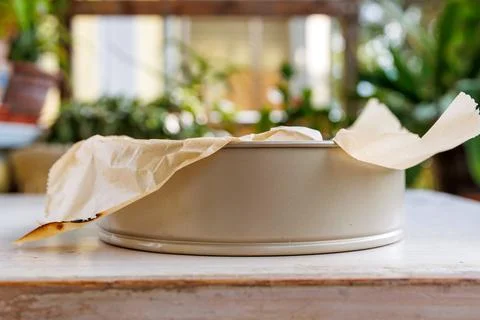 Low side view of a round springform baking pan lined with crumpled parchmen.. Stock Photos