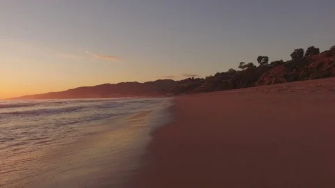 Low slow fly over santa monica beach sunset sand Stock Footage 83964098