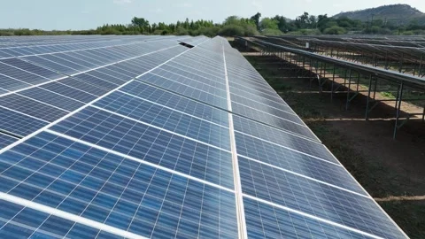 Low slow flyover as solar panel array aimed toward sun produces energy Vídeo Stock 345332276
