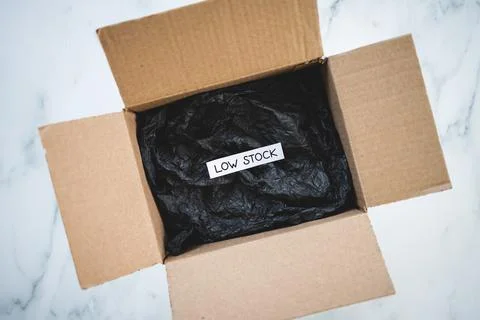 Low stock text inside of empty delivery parcel, supply chain shortages and de Stock Photos