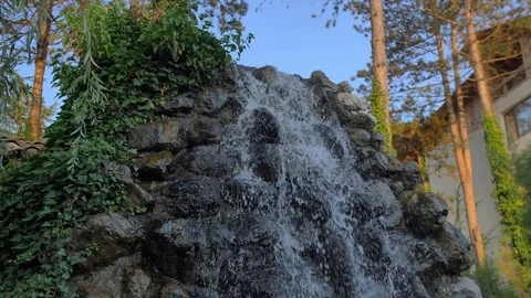 Low stony waterfall,covered with greenery which splashes fly,in courtyard house 스톡 동영상 106087570