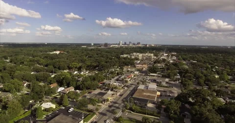 Low storefront strip through a leafy neighborhood street Vídeo Stock 64816189