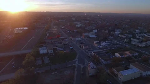 Low sun flaring above a highway and a commercial avenue Vídeos de archivo 63064004