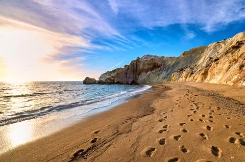 Low sun over beach, cliffs and hills and deep azure sea. Agios Ioannis beach Stock Photos