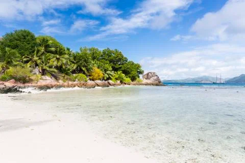 Low tide at Anse Severe in La Digue, Seychelles with some palm trees and gran Stock Photos