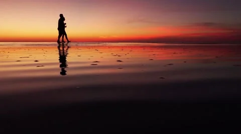Low Tide Sunset Beach sunset couple silhouette walking on sand beach horizon Video stock 45519544