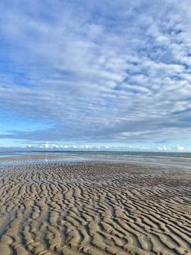Low Tide with Waves on the Sandy Beach Stock Photos