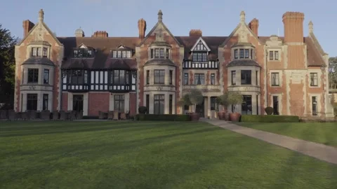 Low tracking move across lawn and front facade of Victorian mansion Wood Norton Stock Footage 284249999