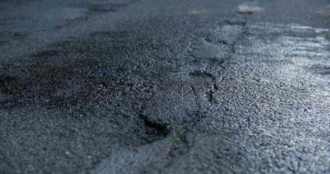 Low Tracking Shot of Wet, Cracked Asphalt Road Without Vehicles - Evening Vídeo Stock 201281891