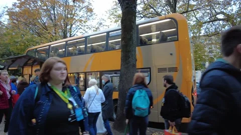Low tracking view of a bus stop with long queue of people Stock Footage 170318952