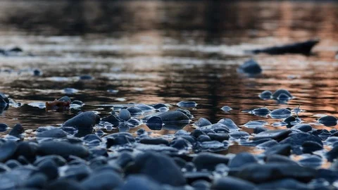 Low vantage loop ready shot of the spring sunset on a rippling river, crimson Stock Footage 128532452