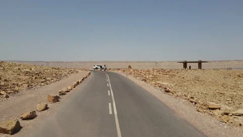 Low view on a desert road next to people walking with a view at the end, Israel Stock Footage 152033574