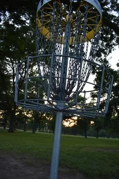 Low View of Disc Golf Basket at Sunset in a City Park Foto stock