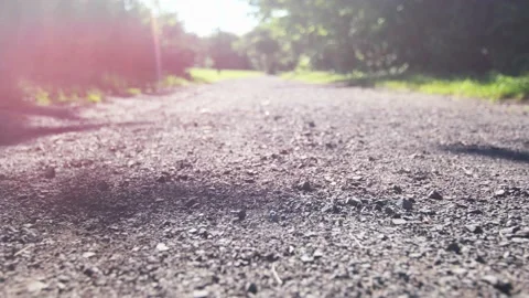 Low view gravel path in slow motion with lens flares Vídeo Stock 130866344