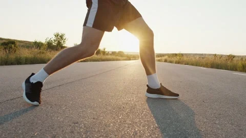 Low view of kickboxer training kicks on road singly during blinding sunset Stock Footage 140262882