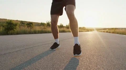 Low view of kickboxer's legs during training kicks on country road singly Stock Footage 140262970