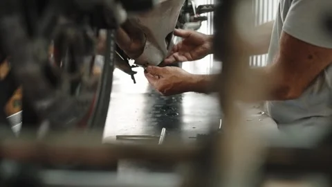 Low view of a mechanic working in a motorcycle workshop Stock Footage 346183205