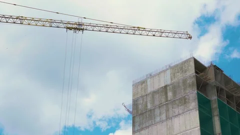 Low view of self-erection tall tower crane near the concrete Industrial building Stock Footage 110603076