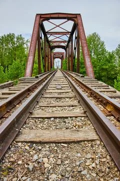 Low view of train tracks leading to rusty iron railroad bridge on Heart of Ohio Stock Photos