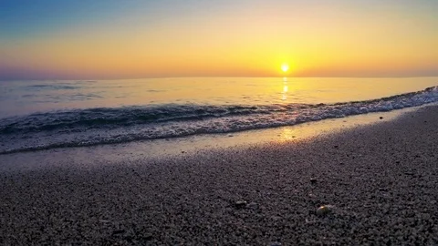 Low view of waves crashing on the shore at sunrise Stock Footage 103285432