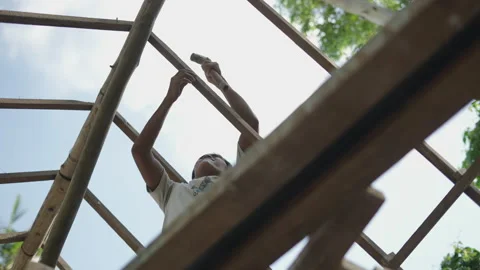Low view of Young asian man using a hammer to create a roof Stock Footage 232581689