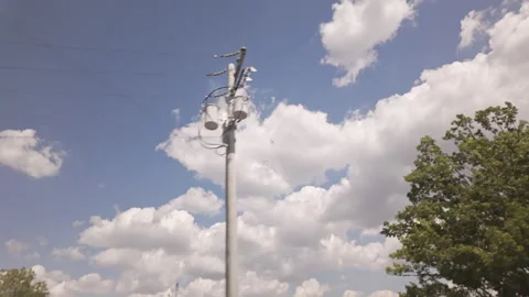 Low-voltage transmission lines and utility poles filmed at low angle, tracking Stockbeeldmateriaal 337182061