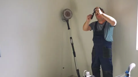 Low wages for construction workers. A plasterer at a construction site checks Stock Footage 322731172