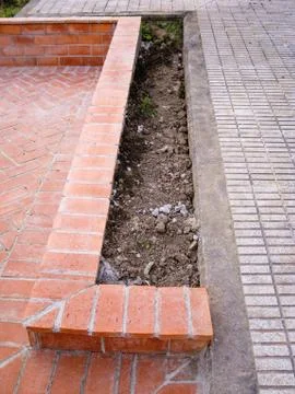 Low wall built with orange brick paving stones Stock Photos