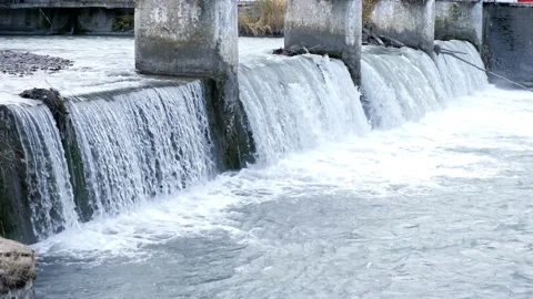 Low waterfall under the stone pillars of the bridge Stock Footage 145513574