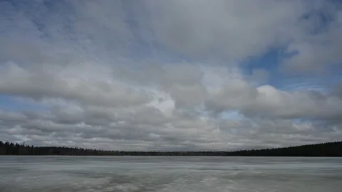 Low white clouds are moving above a frozen lake in this time lapse  Stock Footage 152169146