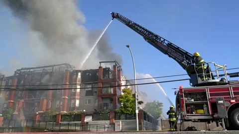 Low wide angle of firefighters fighting with the flames at a building. Stock Footage 135434941