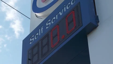 Low to wide angle of gas station price board marked at zero, low supply Stock Footage