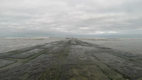 Lowangle view of a wavebreaker on a cloudy day Stock Footage 309293910