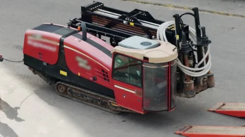 A lowboy trailer is being used to transport a modern horizontal boring machine Stock Footage 318907441