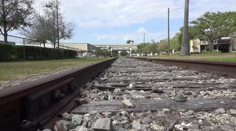 Lowe Angle Close Up Tracking Shot Train Tracks With Freeway In Distance 스톡 동영상 47453485