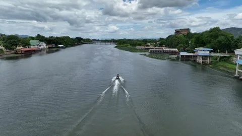 Lower angle chase long tail boat on the Kanchanaburi river, day time. Video stock 248827826