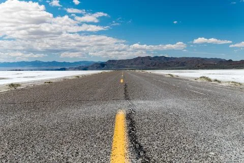 Lower angle of an empty road with some mountains on the horizon surrounded by Foto stock