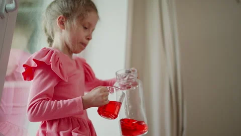 Lower Angle Of Princess Pouring Red Drink Into Clear Glass While Drinking Stock Footage 307976704