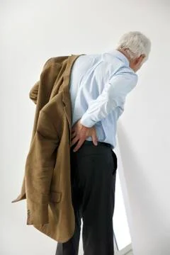 Lower back pain in elderly pers. Stock Photos