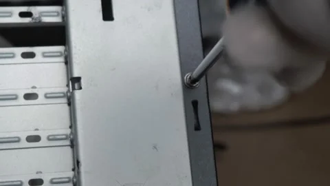 From the lower back of the PC case, Unscrew the bolt Stock Footage 131095036