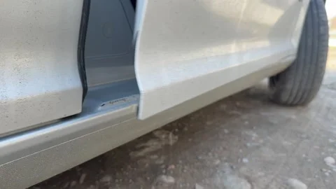 Lower edge of a silver car door moves as the door opens and slams shut, vehicle Stock Footage 337113973