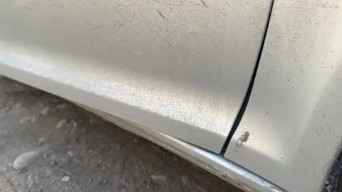 Lower edge of a silver car door moves as the door opens and closes, close-up of Stock Footage 337113982