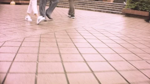 Lower ground leg level view walking around on street with pink floor tiles durin Stock Footage 236229704