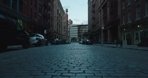 Lower Manhattan low to the ground middle of cobblestone street morning Stock Footage 217980788