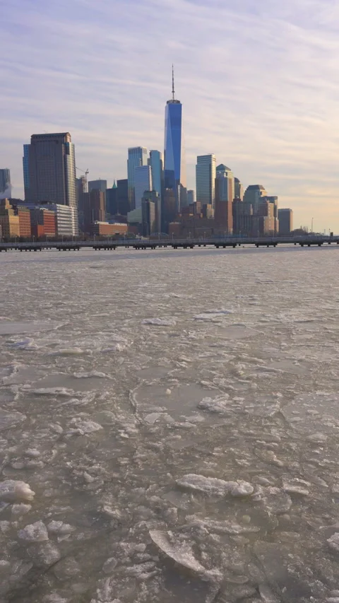 Lower Manhattan skyscraper stands behind frozen Hudson River in New York City. Vídeo Stock 300739853