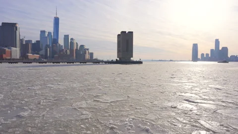Lower Manhattan skyscraper stands behind frozen Hudson River in New York City. Vídeo Stock 301672102
