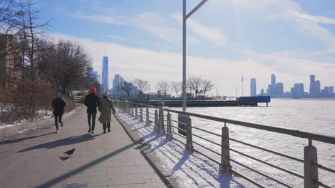 Lower Manhattan skyscraper stands beyond frozen Hudson River in New York City. Video stock 300503641