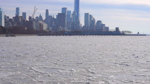 Lower Manhattan skyscraper stands beyond frozen Hudson River in New York City. Stock Footage 300628383